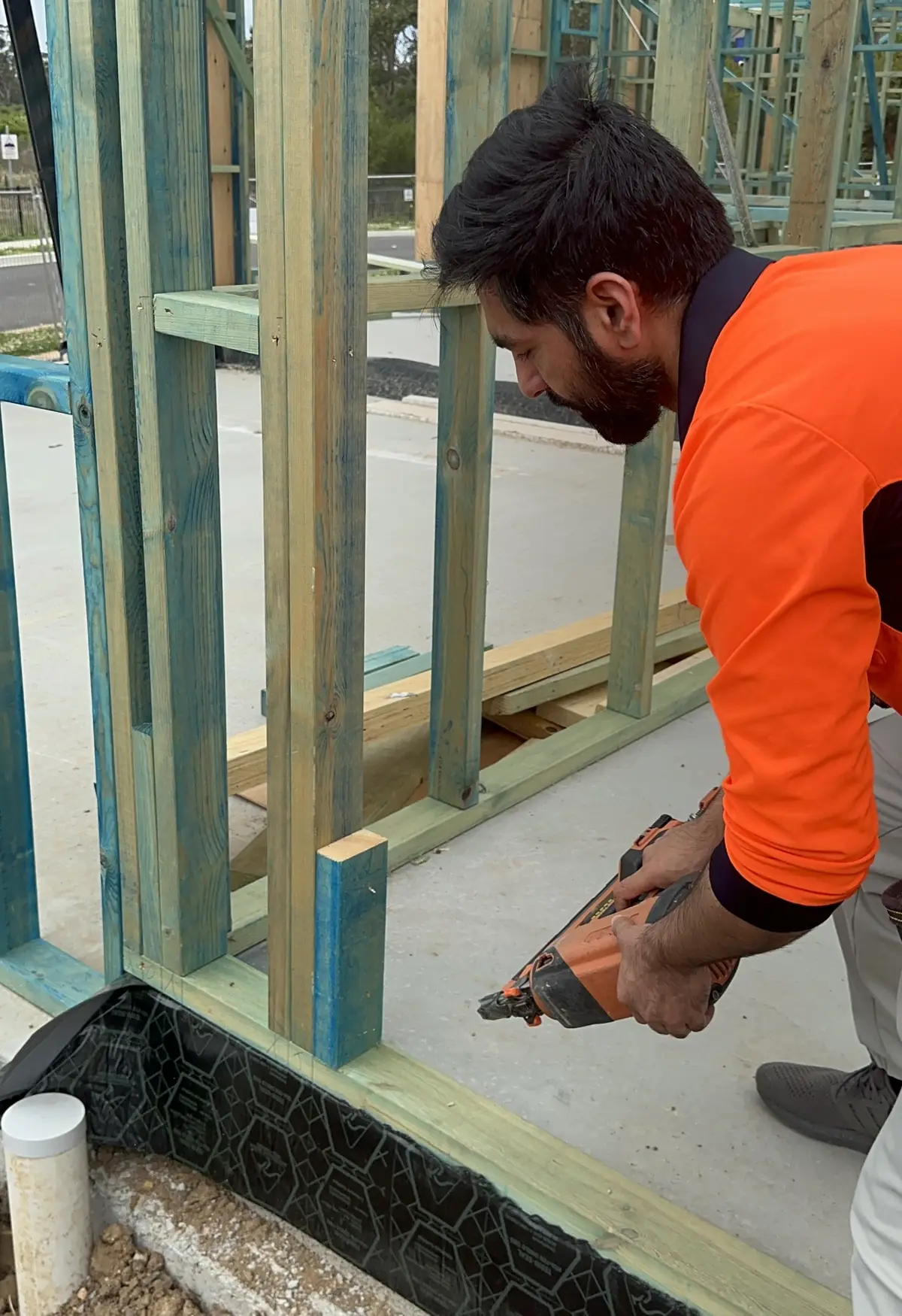 Ali Arshad nailing off a timber wall frame with a nail gun