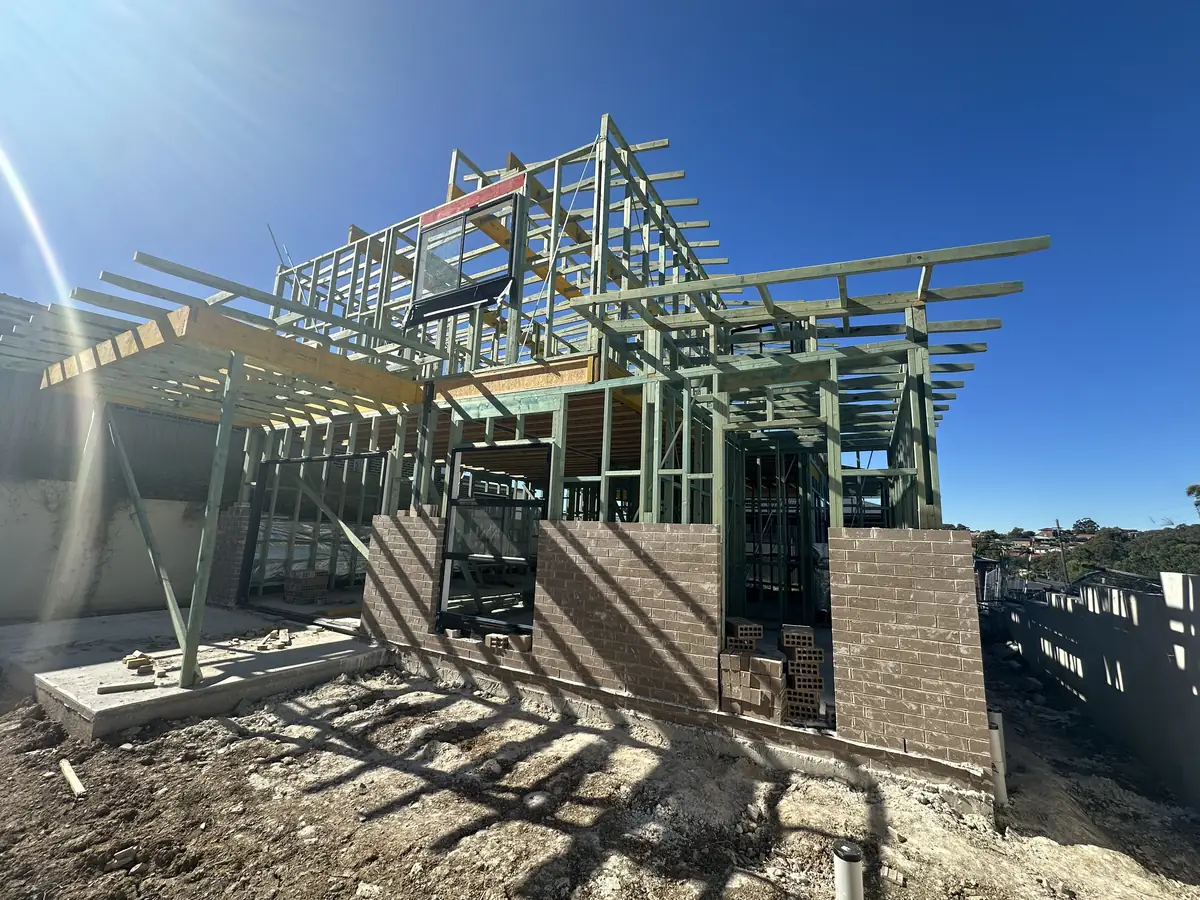 Timber framing and roof structure rising above brickwork