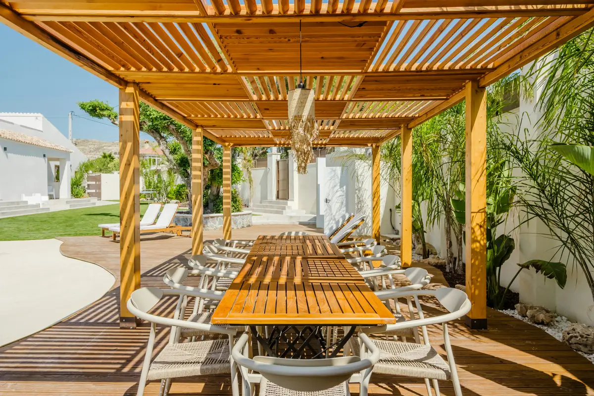 Timber pergola over a deck with an outdoor dining table